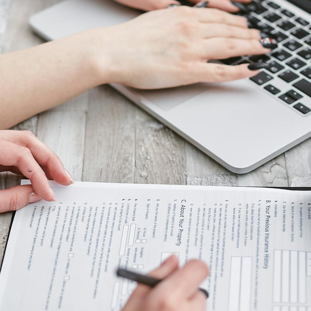 Team completing documentation and entering information on a laptop as part of a cybersecurity risk assessment process.