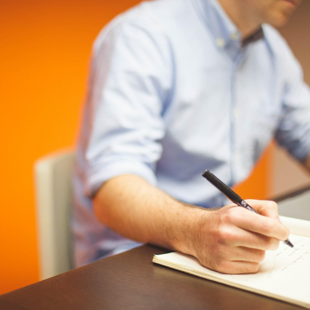 vCISO reviewing security notes and documenting cybersecurity strategy during an IT risk assessment session.